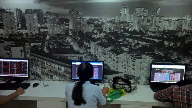 Các nhà đầu tư theo dõi bảng giao dịch chứng khoán tại Công ty VNDirect - Sài Gòn, tháng 8-2015